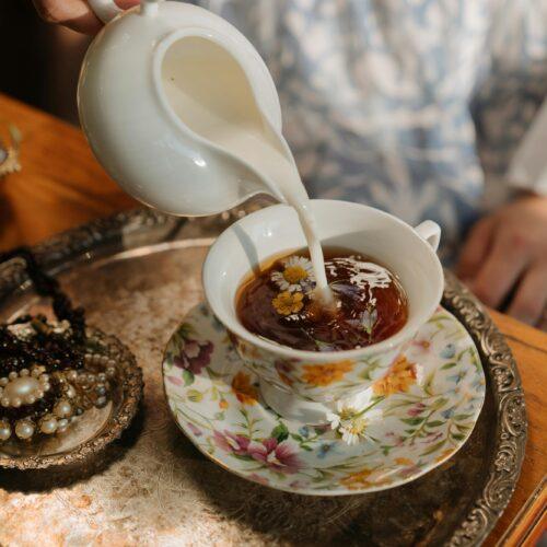 Close-up of a barista pouring creamy milk into coffee, representing how to use homemade cannamilk in drinks.