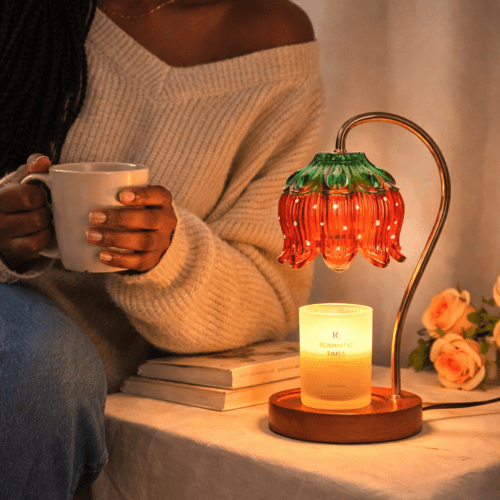 Strawberry candle warmer lamp with a jar candle underneath on a bedside table