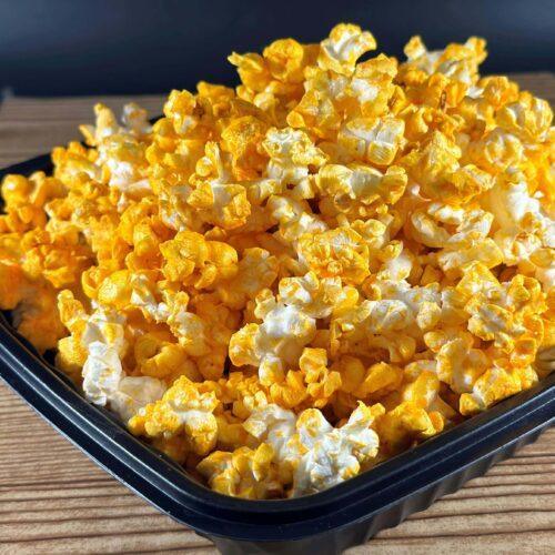 Warm bowl of cannabis infused popcorn styled on a neutral coffee table for a cozy night in